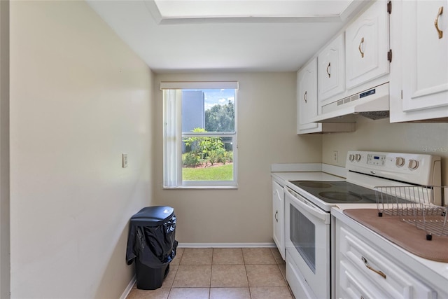 kitchen with electric stove, custom exhaust hood, light tile patterned floors, and white cabinetry