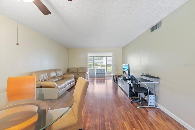 living room featuring a textured ceiling, dark hardwood / wood-style flooring, and ceiling fan