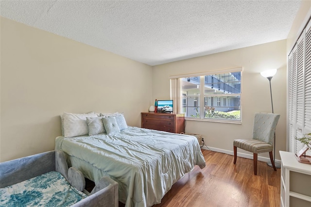 bedroom featuring a textured ceiling, hardwood / wood-style floors, and a closet