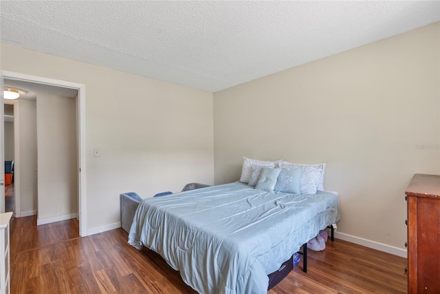 bedroom featuring a textured ceiling and dark wood-type flooring