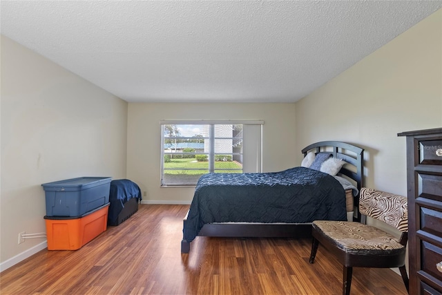 bedroom with wood-type flooring and a textured ceiling