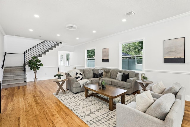 living room featuring ornamental molding and light hardwood / wood-style flooring