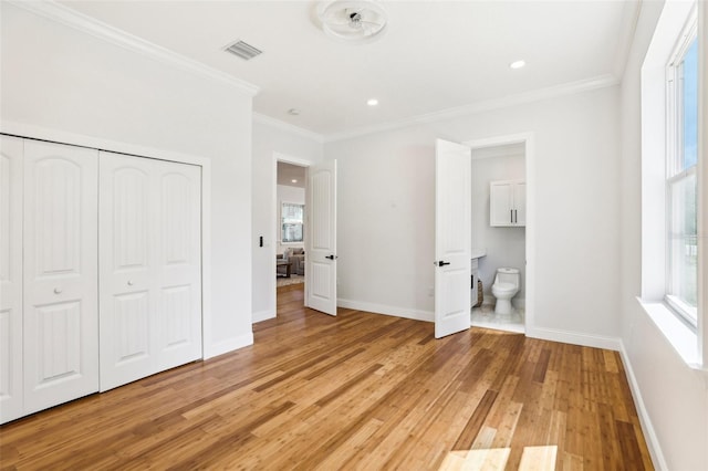 unfurnished bedroom with ornamental molding, light hardwood / wood-style floors, and multiple windows