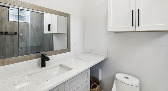 bathroom featuring an enclosed shower, vanity, and toilet