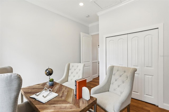 living area with wood-type flooring and ornamental molding