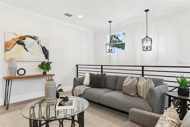 living room with wood-type flooring, a chandelier, and ornamental molding