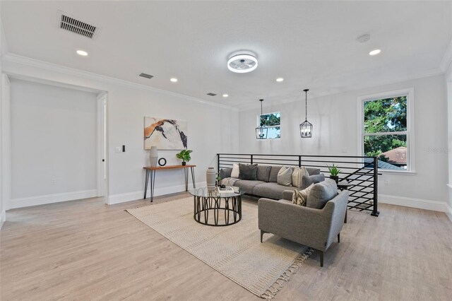 living room with ornamental molding and light hardwood / wood-style floors