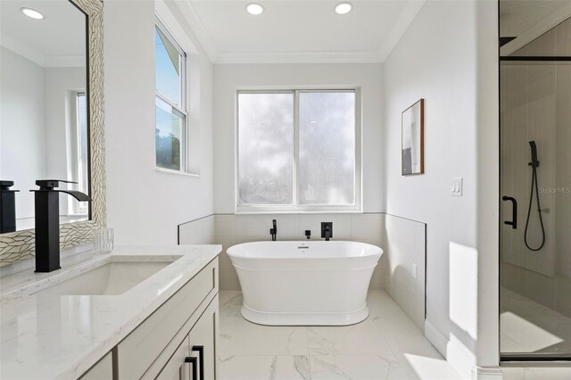 bathroom with vanity, tile walls, crown molding, and separate shower and tub