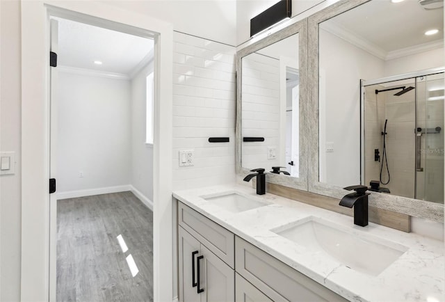 bathroom with crown molding, wood-type flooring, vanity, and an enclosed shower