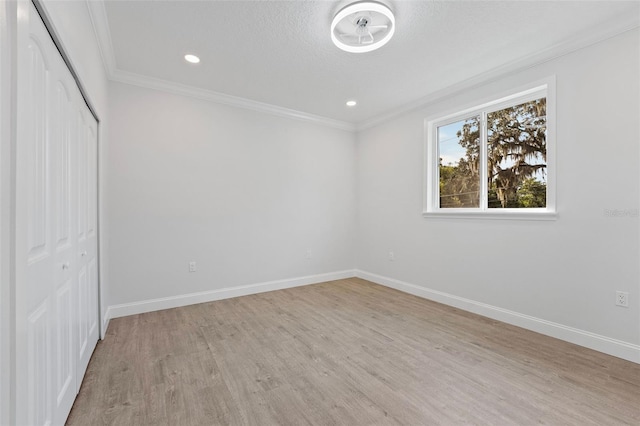 unfurnished bedroom with a closet, light wood-type flooring, ornamental molding, and a textured ceiling