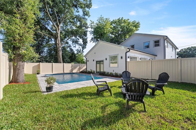 view of swimming pool featuring a fire pit, a lawn, and a patio