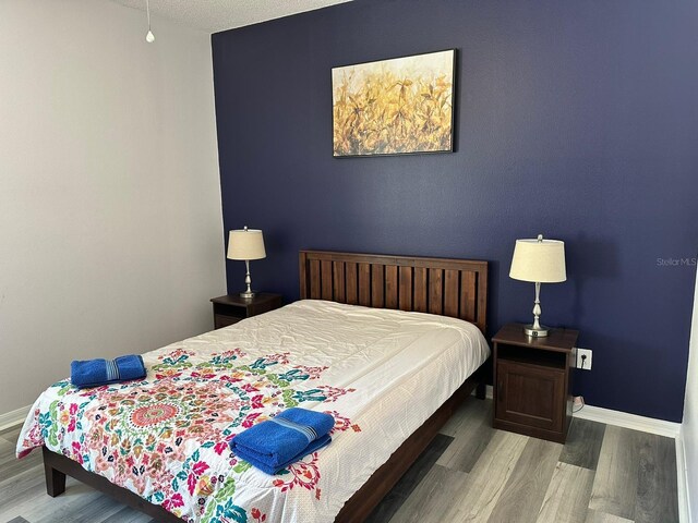 bedroom featuring a textured ceiling and wood-type flooring