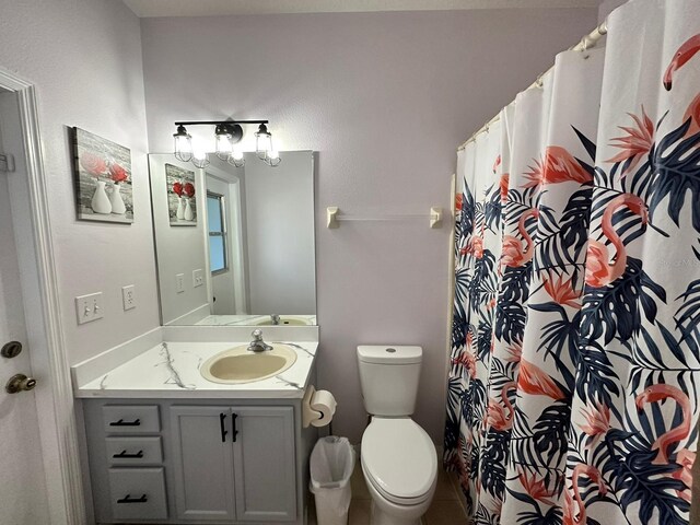 bathroom featuring walk in shower, toilet, and vanity