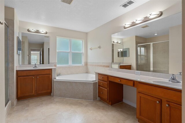 bathroom featuring vanity, a textured ceiling, and shower with separate bathtub