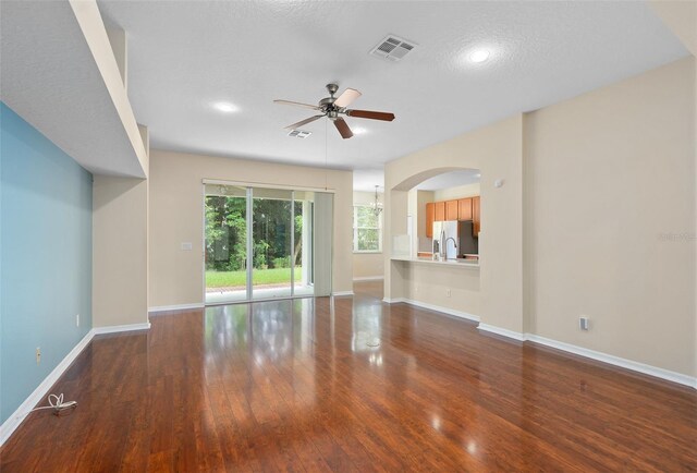 unfurnished living room featuring a textured ceiling, hardwood / wood-style floors, and ceiling fan