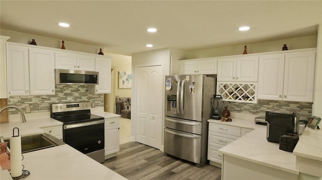 kitchen featuring white cabinetry, hardwood / wood-style flooring, stainless steel appliances, and sink