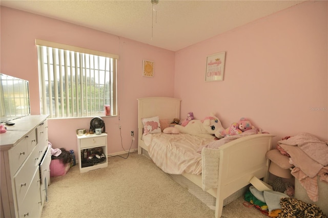 bedroom featuring a textured ceiling and light colored carpet