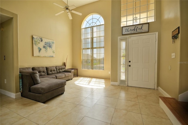 tiled entryway featuring a high ceiling and ceiling fan