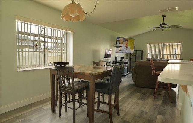 dining space with ceiling fan, lofted ceiling, and dark hardwood / wood-style flooring