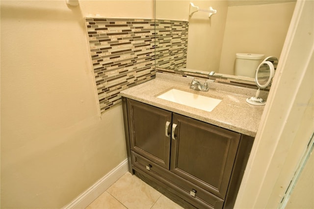 bathroom with vanity, toilet, decorative backsplash, and tile patterned flooring