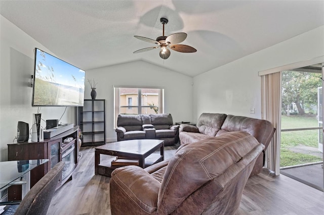 living room featuring ceiling fan, vaulted ceiling, a textured ceiling, and hardwood / wood-style floors