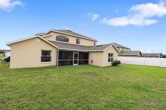 back of property featuring a lawn and a sunroom