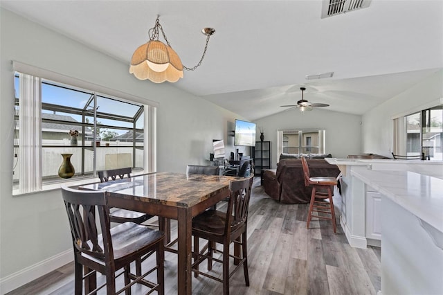 dining room with light wood-type flooring, vaulted ceiling, and ceiling fan