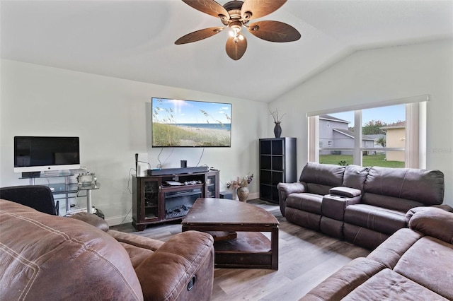 living room featuring light hardwood / wood-style floors, lofted ceiling, and ceiling fan