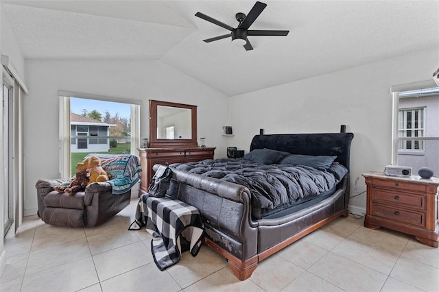 tiled bedroom with ceiling fan, vaulted ceiling, and a textured ceiling