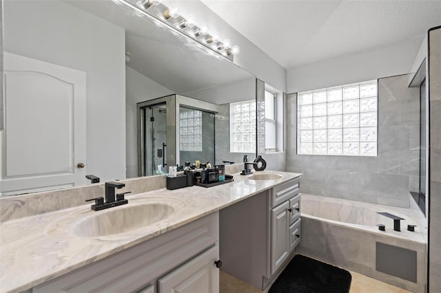 bathroom featuring plus walk in shower, vanity, and lofted ceiling