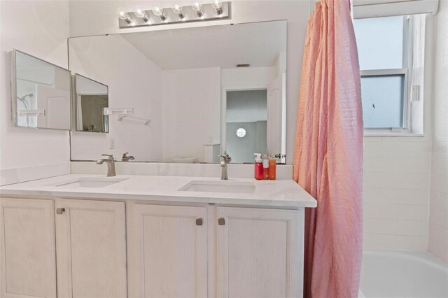 bathroom featuring shower / bath combination with curtain and vanity