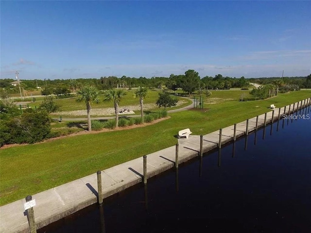 view of community with a rural view, a yard, and a water view