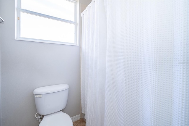 bathroom featuring a shower with curtain and toilet