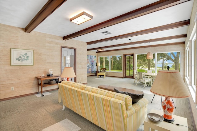 living room with beam ceiling and light colored carpet