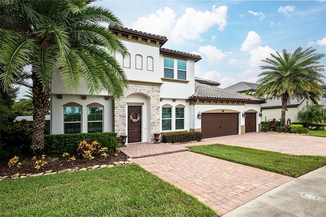 mediterranean / spanish-style home with a front yard and a garage