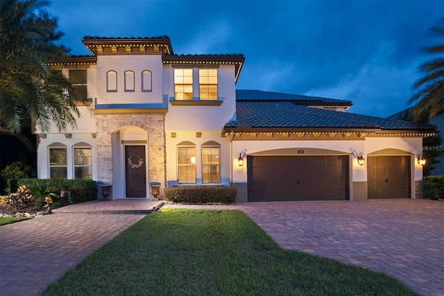 mediterranean / spanish-style house with a yard and a garage