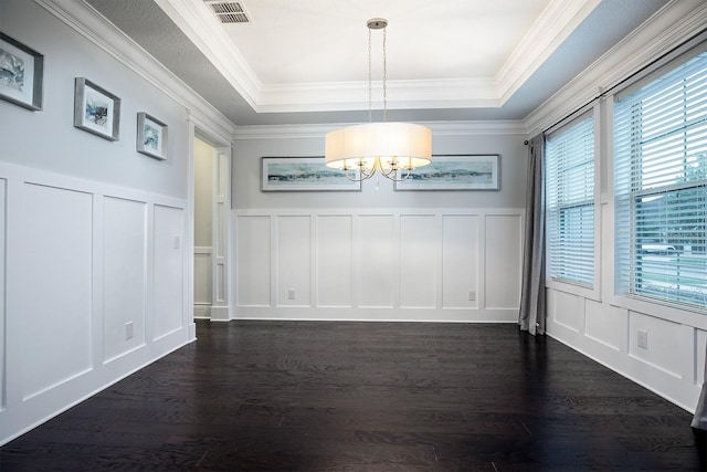 unfurnished dining area with a raised ceiling, crown molding, dark hardwood / wood-style floors, and a chandelier