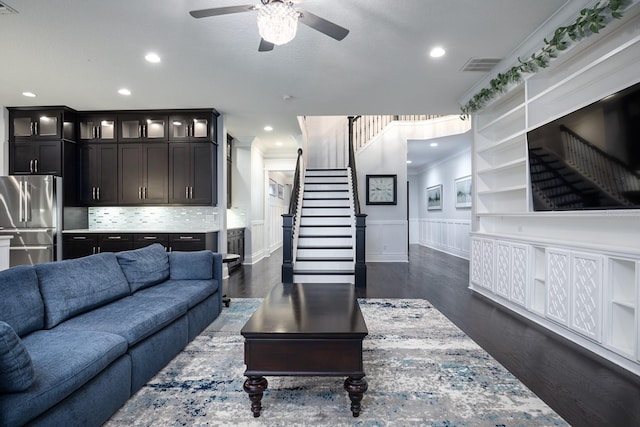 living room featuring ornamental molding, ceiling fan, and dark hardwood / wood-style floors