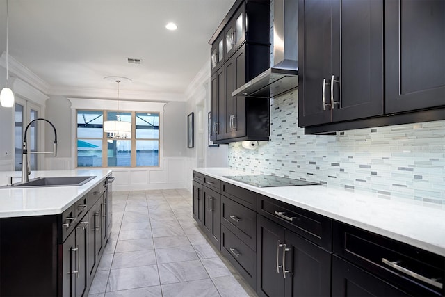 kitchen with wall chimney exhaust hood, sink, hanging light fixtures, and black electric cooktop