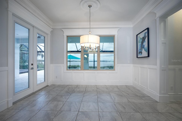 unfurnished room with a notable chandelier, ornamental molding, and french doors