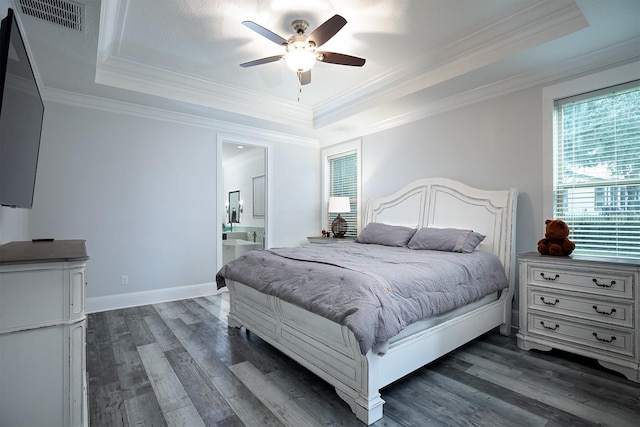 bedroom featuring connected bathroom, a raised ceiling, dark hardwood / wood-style flooring, ornamental molding, and ceiling fan