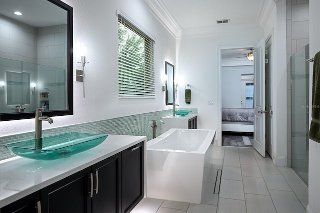 bathroom featuring ceiling fan, ornamental molding, vanity, and separate shower and tub