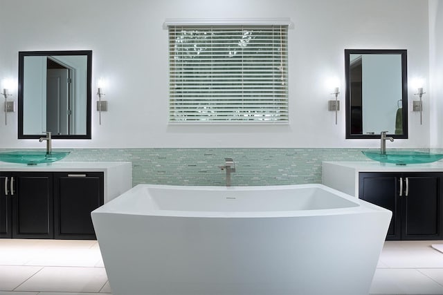 bathroom with vanity, a washtub, and tile patterned floors