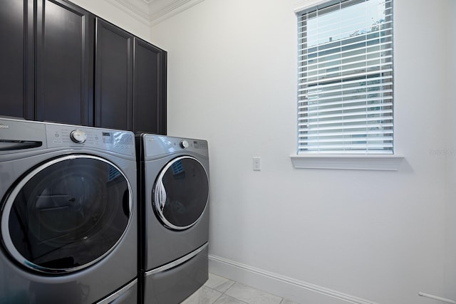 clothes washing area with crown molding, plenty of natural light, washer and dryer, and cabinets