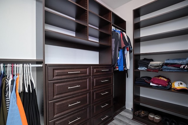 walk in closet with light hardwood / wood-style floors