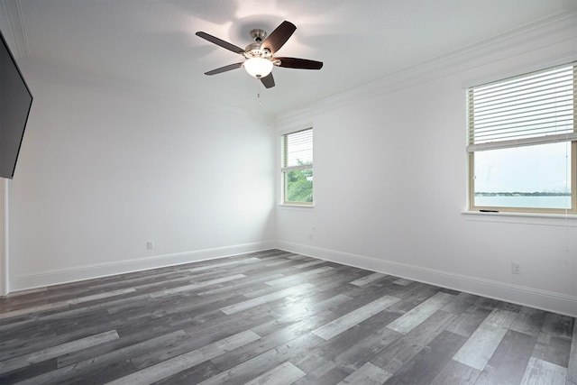 unfurnished room with ornamental molding, ceiling fan, and dark wood-type flooring