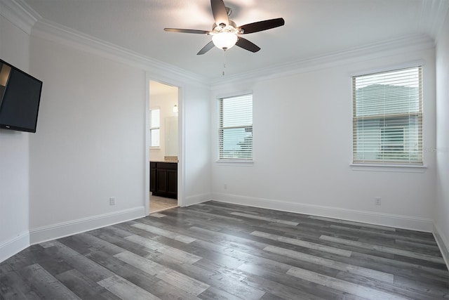 unfurnished bedroom featuring ensuite bath, multiple windows, and dark hardwood / wood-style floors