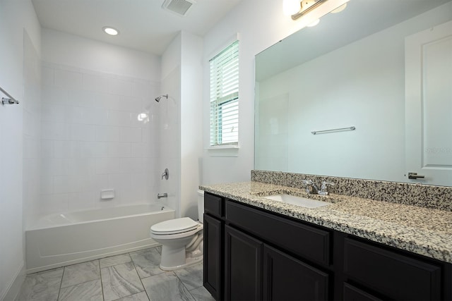 full bathroom featuring tiled shower / bath combo, vanity, and toilet