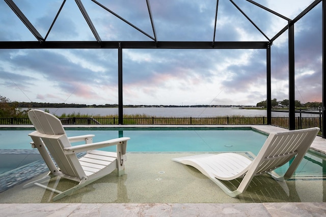 view of swimming pool with a patio, a water view, and a lanai