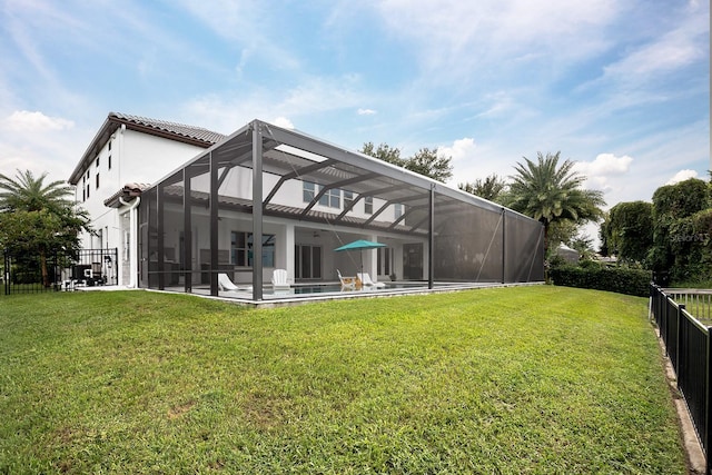 rear view of property with glass enclosure, a patio area, a pool, and a yard